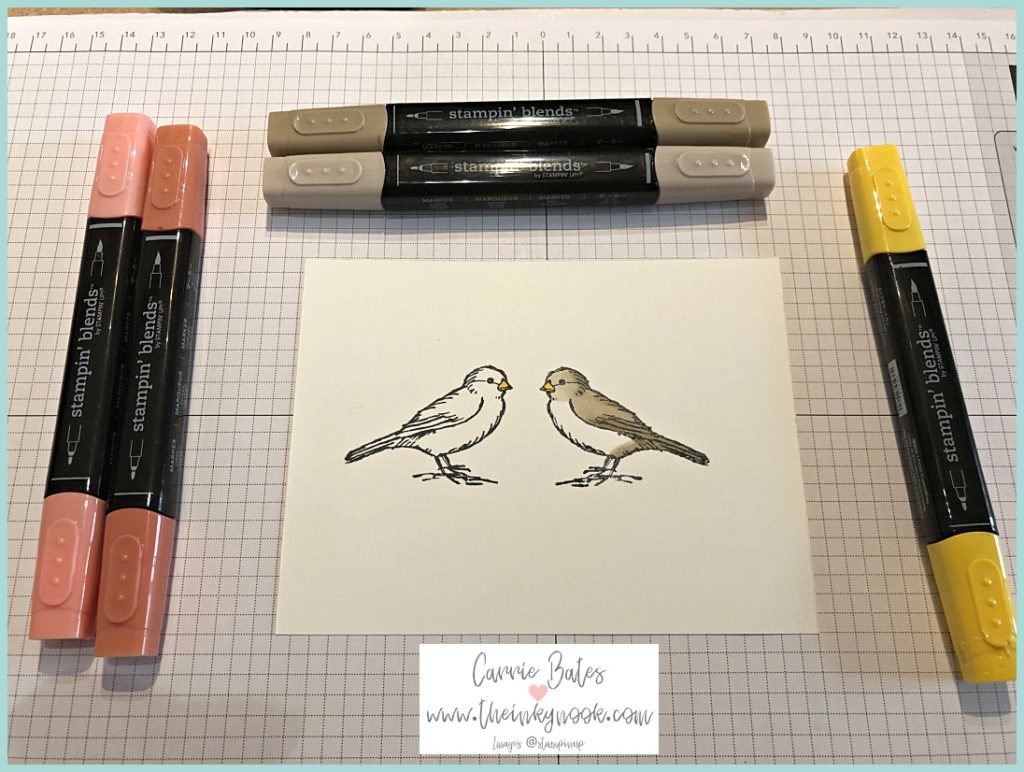 White card showing two birds facing each other.  They are partially coloured in and surrounded by Stampin' Blends pens. The two birds face each other as one has used the reverse stamp technique.