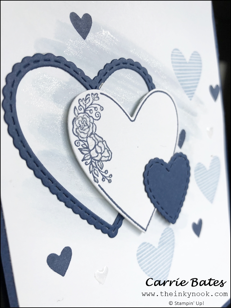 Close up of navy blue card with a white layer decorated with a light blue glittery watercolour wash and topped with light blue and dark blue stamped hearts.  Three white and blue heart diecuts in descending sizes embellish the front. Sapphire wedding anniversary card