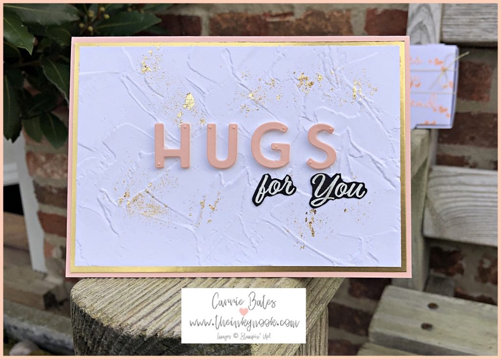 Petal pink card base topped with a gold layer.  This then has an embossed white layer with an antique finish and gold flake gilding randomly over the top.  The word "hugs" has been die cut and stuck on top of the white layer with foam pads.  The words "for you" are heat embossed in white on black card and fussy cut before gluing underneath the word "hugs".