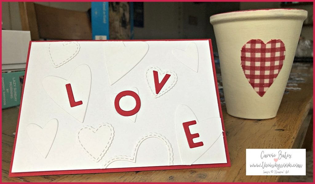 How to make your own valentine card - image shows red card with a white layer covered in different sized white heart shapes.  The word "LOVE" is spelt out in red letters across the card.