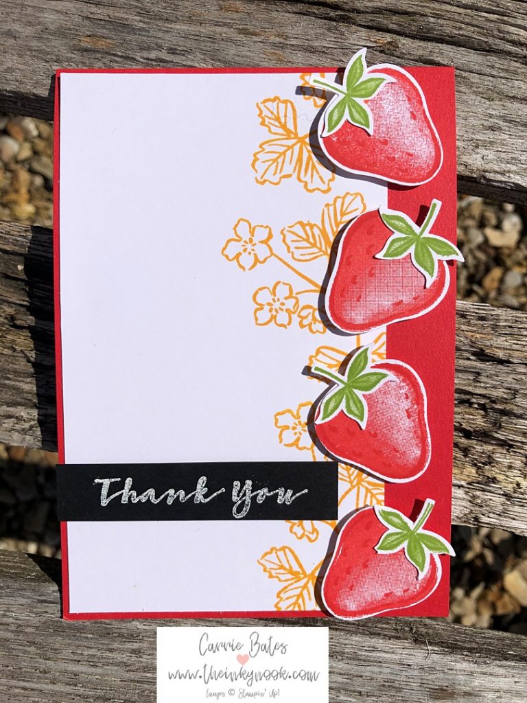 Strawberry thank you card with handstamped and punched strawberries along the edge.  Background shows yellow strawberry flowers and stems.  Topped with a white embossed sentiment, thank you, on black card