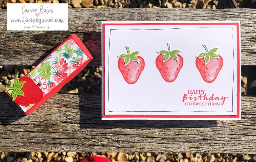 Strawberry birthday card showing 3 individual strawberries on a red card layer and white card base.  A small red treat box is pictured next to the card topped with fruit themed paper and a punched out strawberry.