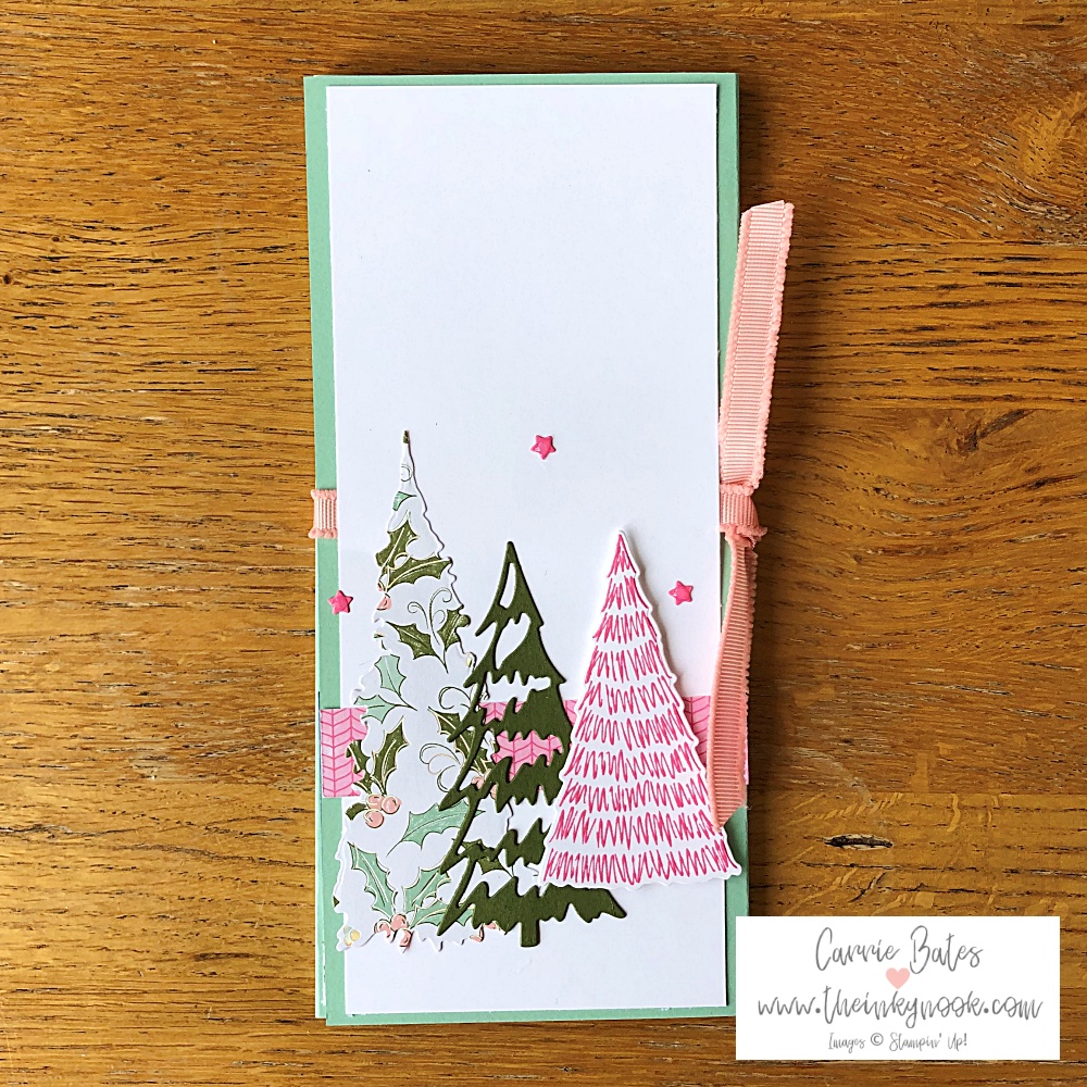 Front view of tri-fold card in a mint colour with a layer topped with 3 Christmas trees in pinks and greens.  All tied together with a pink ribbon