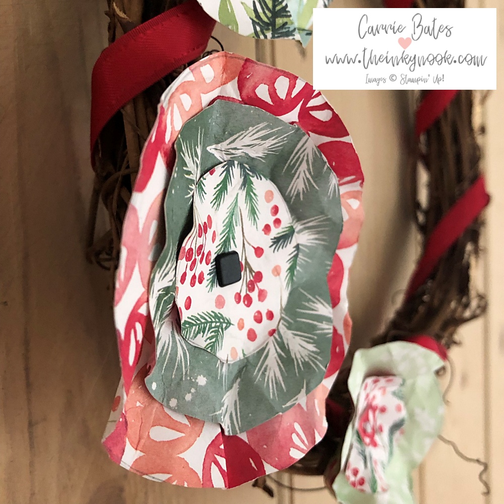 Christmas gift wreath using a grapevine wreath base wrapped with ribbon and decorated with flowers made from designer series paper interspersed with golden holly leaves