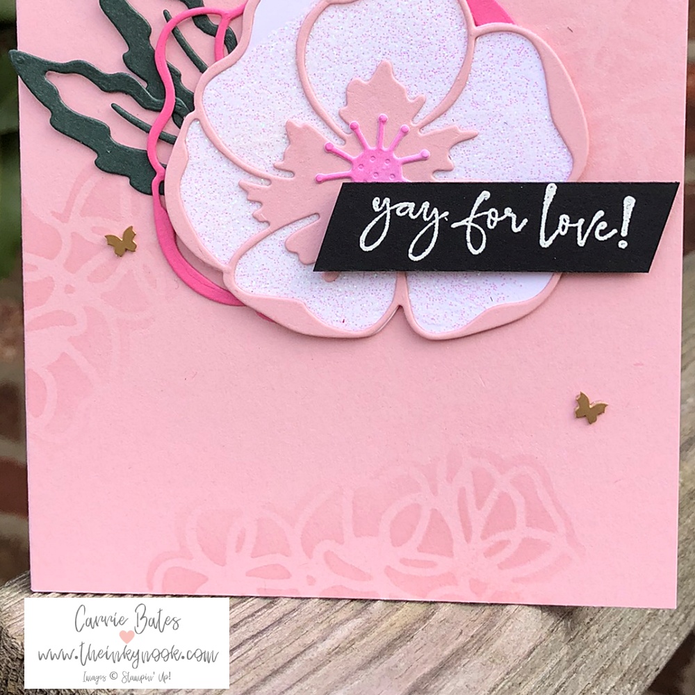 Close up of pink card celebrating love with detailed floral images and a poppy centrepiece made from diecut images. Everything is pink except for the green leaves and black greeting saying "yay for love"