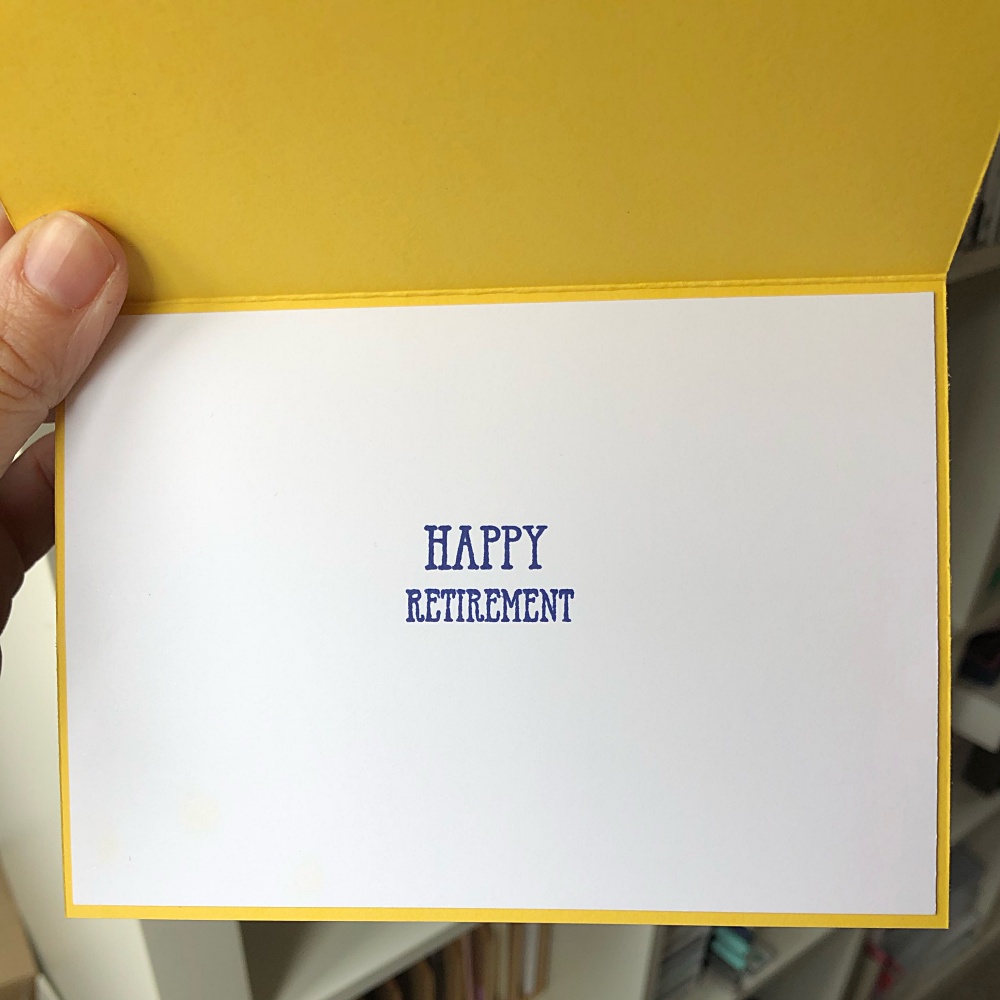 Image shows inside of a handmade retirement card with the greeting, happy retirement, stamped in midnight blue.