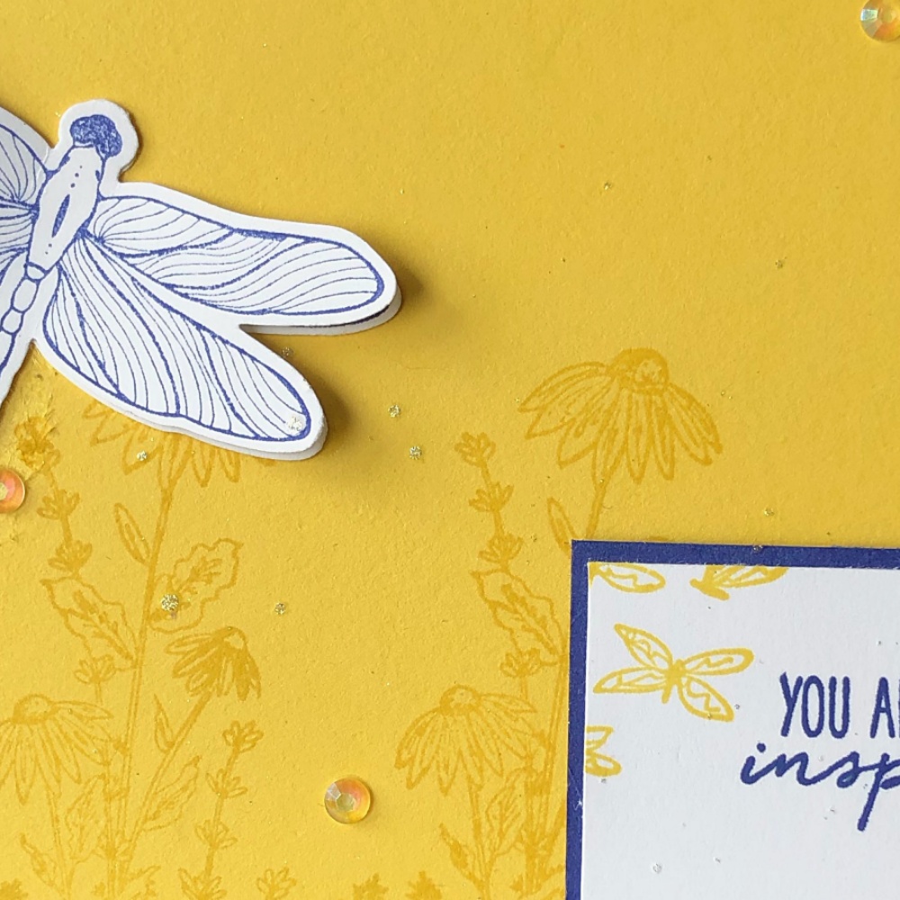 Make a retirement card - image shows a yellow card with wildflowers stamped on it. Topped with a 3D midnight blue dragonfly  and a greeting of "You are a true inspiration"