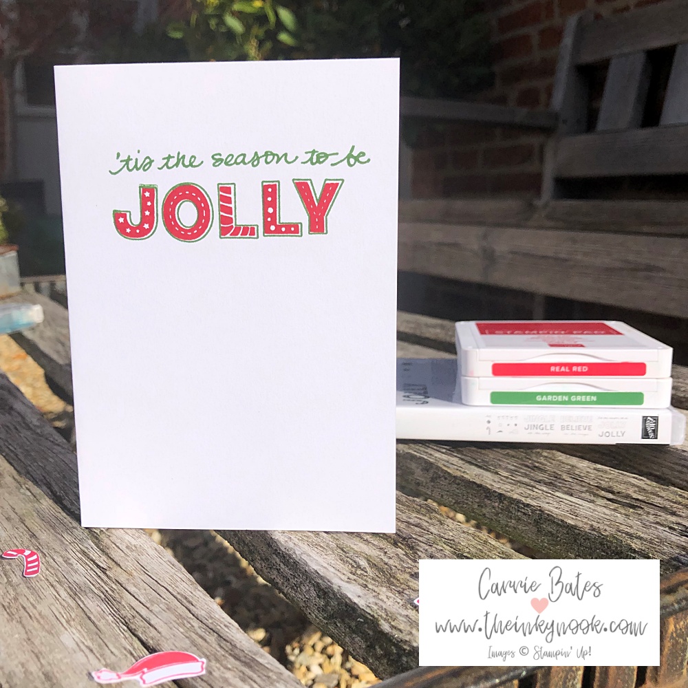 Simple Christmas card on a white card base stamped with the greeting "tis the season to be jolly" in red and green ink