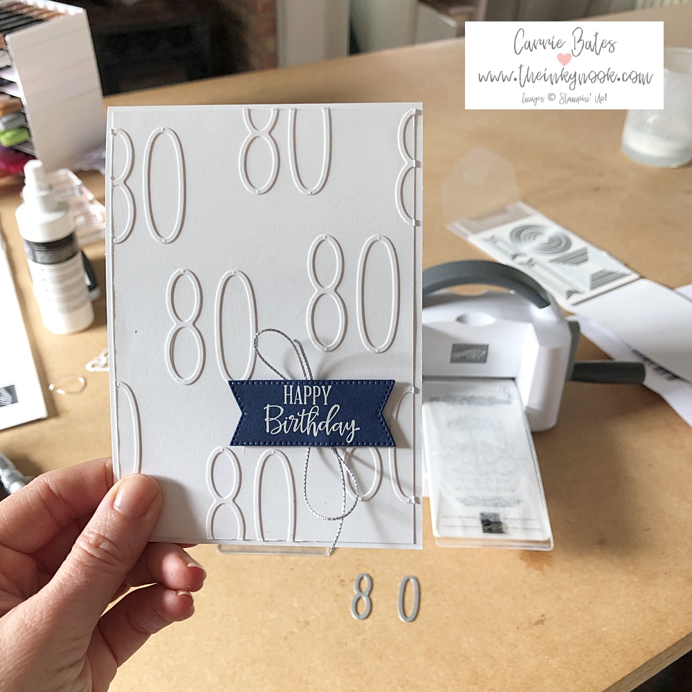 Personalised 80th birthday card  - white card covered with the number 80 in white card die cuts topped with a navy blue label and white embossed happy birthday greeting