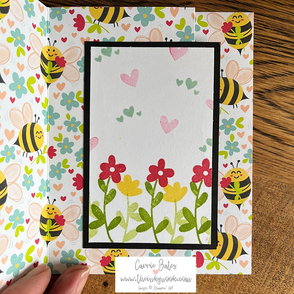 Inside layer of fun fold accordion card showing row of red and yellow flowers, pink and blue hearts on a white background stamped with hearts backed up with floral paper scattered with bumblebees